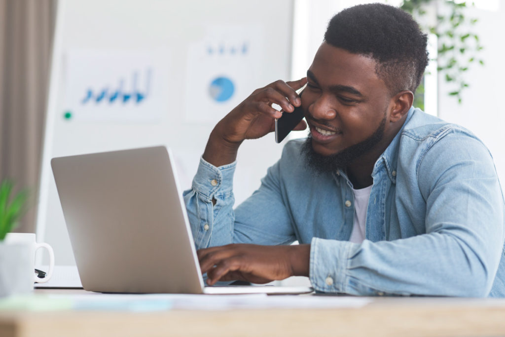 employee-talking-on-cellphone-and-working-on-laptop