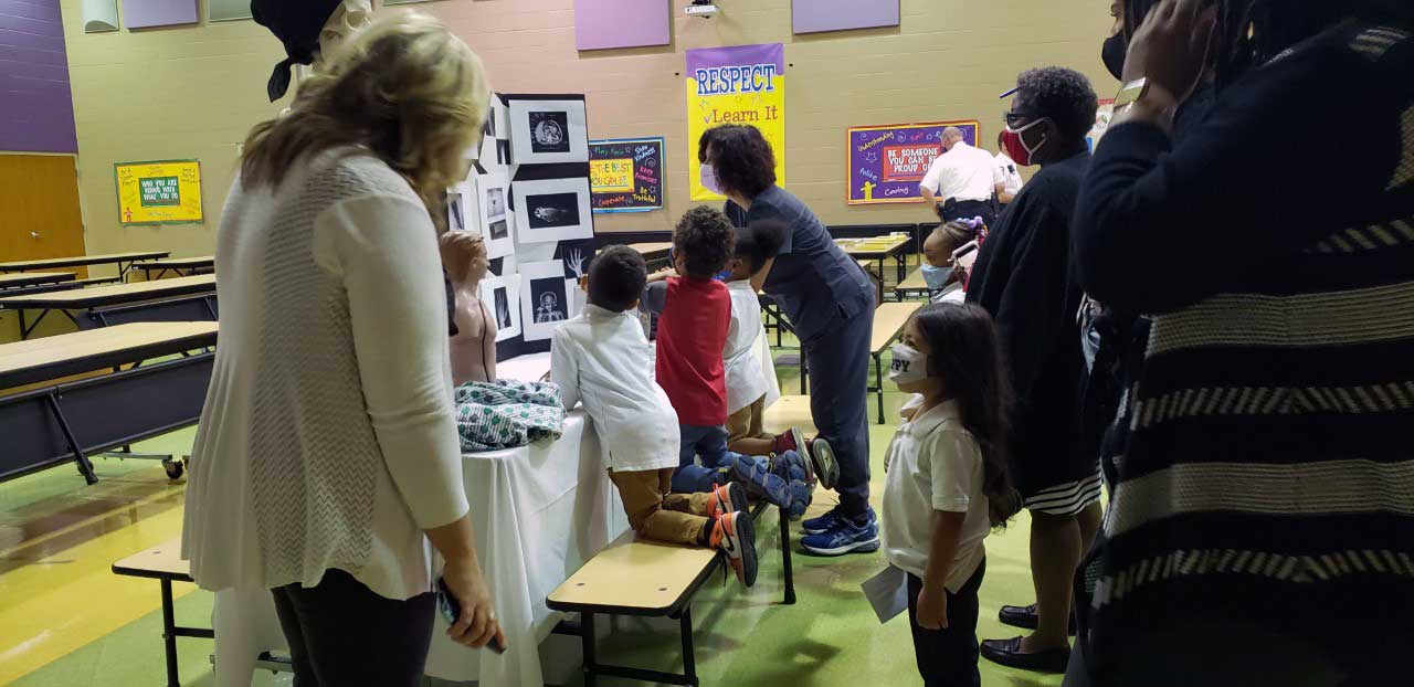 group of people including children looking at a display