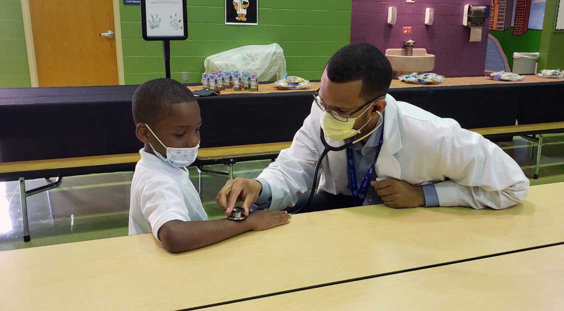 adult checking child's pulse with a stethoscope