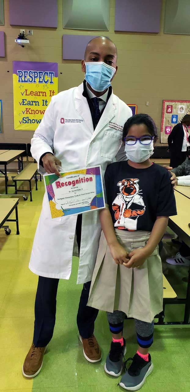 adult and child holding a recognition certificate