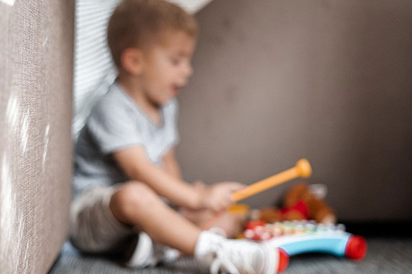 blurry photo of child playing children's xylophone