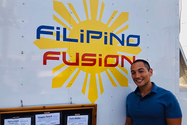 photo of Marc Guerrero standing in front of a truck that says "Filipino Fusion"