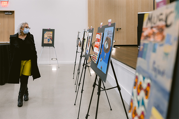 photo of one woman looking at a piece of artwork displayed