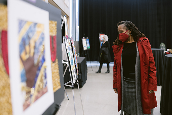 photo of one woman looking at a piece of artwork displayed