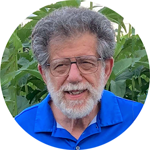 Peter V Paul in a blue shirt in front of some plants