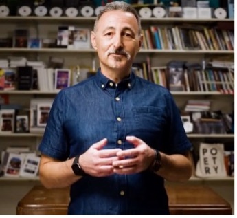 Peter Kahn standing in front of a bookshelf