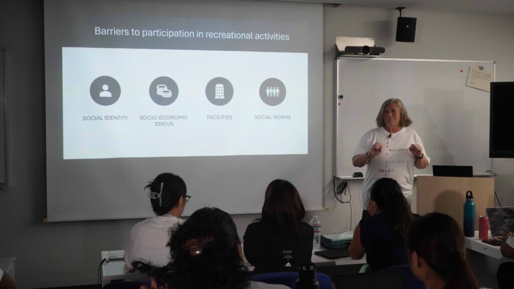 Woman teaching a classroom in front of projector